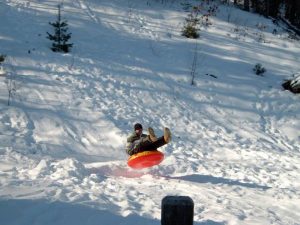 A man on a snow tube in Glenwood Springs, home to some of the best sledding in Colorado