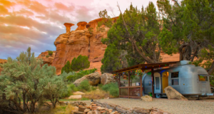 An Airstream trailer nestled into a red rock canyon near Canyon of the Ancients