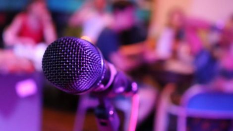 A microphone and audience in a room at a Denver karaoke establishment