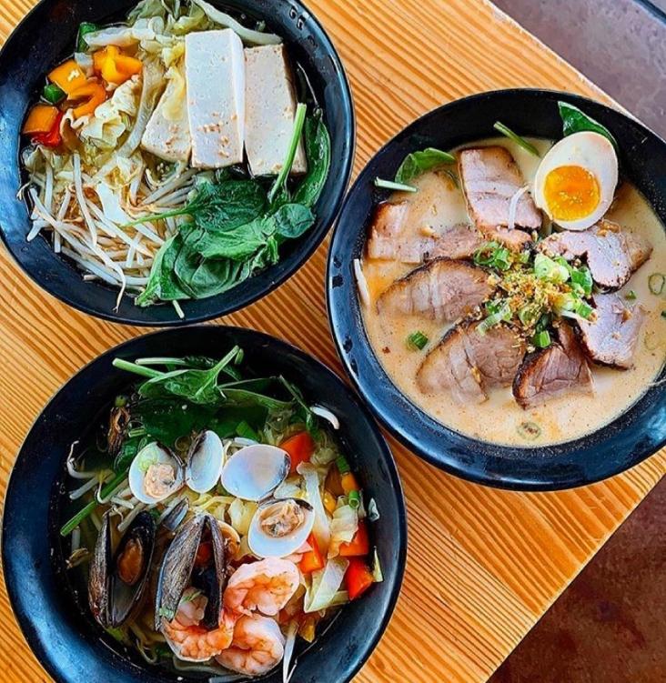 Three bowls of ramen sitting on top of a table