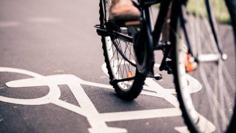 The wheels of a bicycle and a bicycle sign on a street