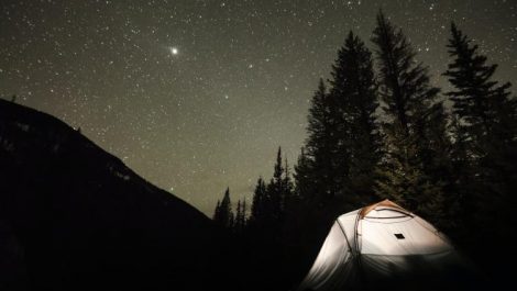 An illuminated tent at one of the free campsites in Colorado, under a night sky