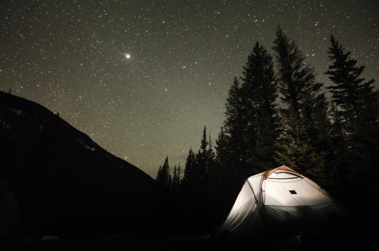 An illuminated tent at one of the free campsites in Colorado, under a night sky