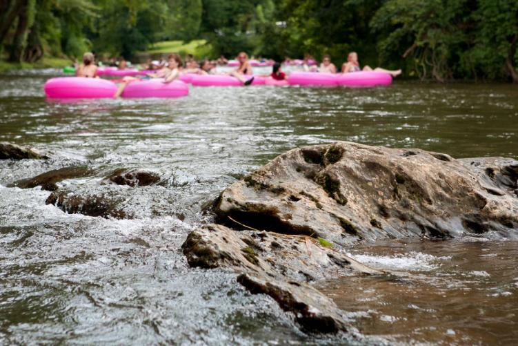 A group of people in pink rafts river tubing in Colorado