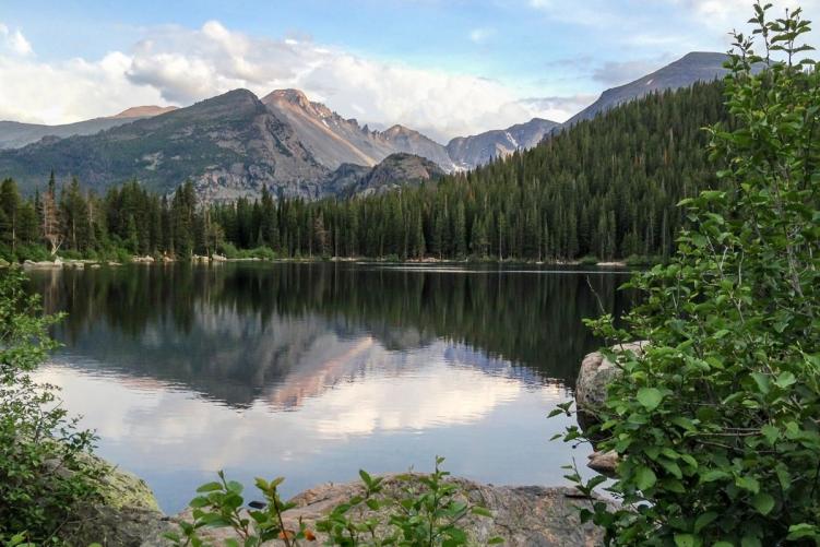 Mountains surrounding Bear Lake with a reflection in Rocky Mountain National Park, where RMNP timed entry permits are now required